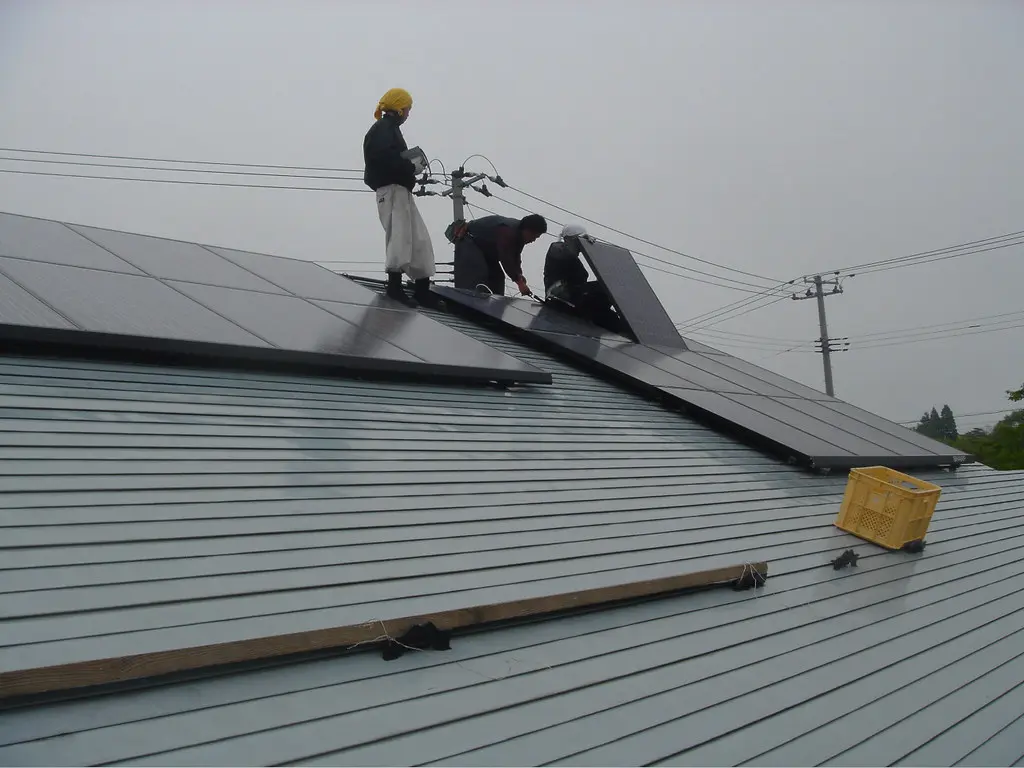 Crew installing solar panels on a roof